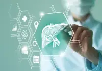 Clinician holding a tablet with a holographic liver and health icons (medical interface).&nbsp;