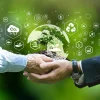 Hands holding a globe with sustainability icons, representing ESG strategy, climate action and environmental responsibility.