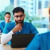 Healthcare professional using a laptop in a clinical training setting, supporting medical education, digital learning and healthcare workforce development.