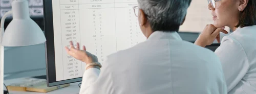 Pathology staff collaborating over digital diagnostics data. 