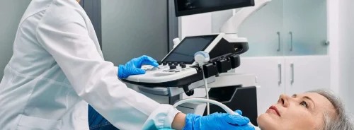 Doctor performing thyroid ultrasound on a senior woman in a hospital clinic. 