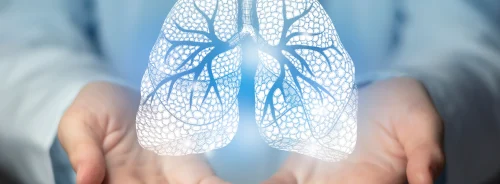 Doctor holding a glowing digital lung icon, symbolising respiratory health, pulmonology and lung disease care.