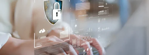 Hands typing on a laptop with a digital security overlay, representing healthcare cybersecurity and data privacy protection.