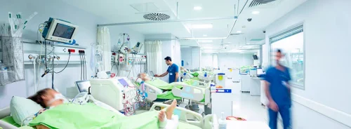 Intensive care unit with patients and monitoring equipment, illustrating critical care delivery and hospital clinical operations.