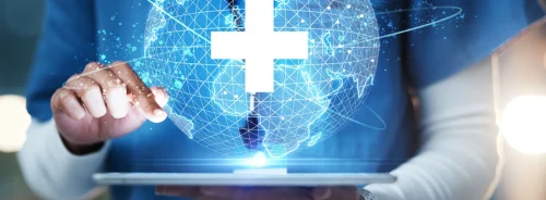Clinician holding a tablet with a global healthcare network visualisation, illustrating connected care systems, cross-border data exchange and digital health integration at scale.