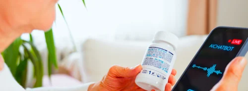 Older patient using an AI chatbot on a smartphone to check medication information, supporting digital health guidance and remote patient support.