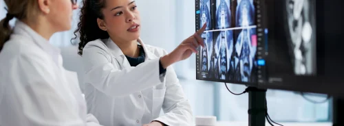 Radiologists reviewing medical imaging on diagnostic monitors, supporting radiology assessment, clinical collaboration and treatment planning.