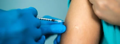 Patient receiving a vaccine injection, supporting immunisation, preventive healthcare, public health protection and clinical care.