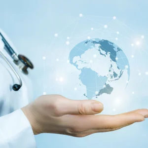 Doctor’s hand presenting a holographic globe with network links, symbolising global healthcare. 