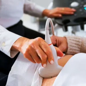 Clinician performing an abdominal ultrasound scan, supporting diagnostic imaging, patient assessment and point-of-care care.