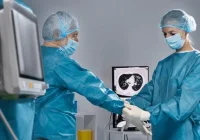 Surgeons donning gloves in a sterile environment before a medical procedure
