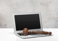 Gavel resting on a laptop keyboard, symbolising digital law or online justice 