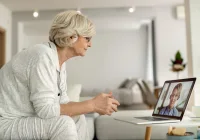 Senior woman having an online medical consultation via video call from home 