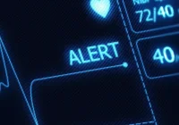 Patient monitor screen displaying an alert and vital signs. 