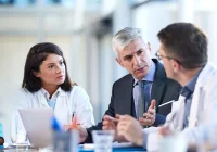 Healthcare leaders and clinicians in a strategic meeting, discussing hospital management, clinical governance and collaborative decision-making.