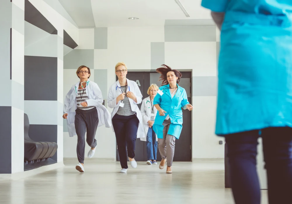 Emergency response in hospital – medical team running to handle urgent patient care situation