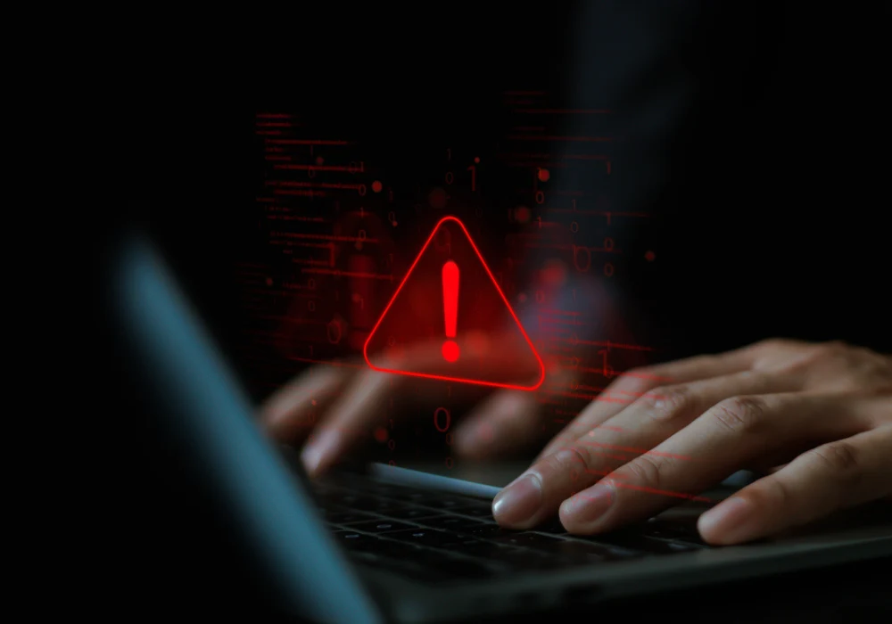 Cybersecurity warning symbol appears on laptop screen during data breach attempt. 