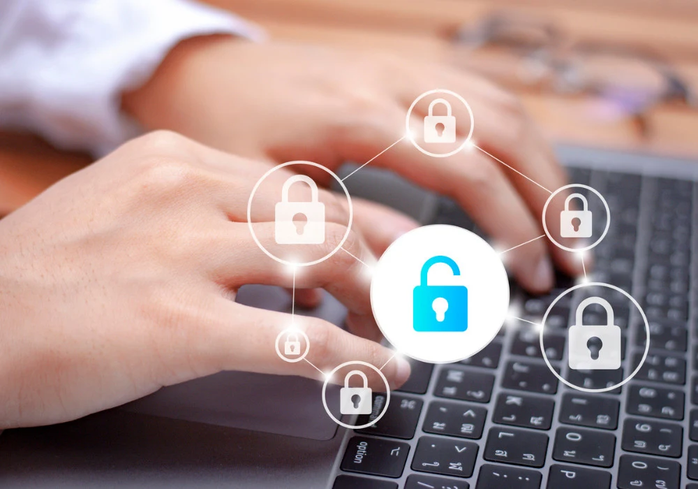 Cybersecurity concept showing person typing on laptop with digital padlock icons symbolising data protection. 