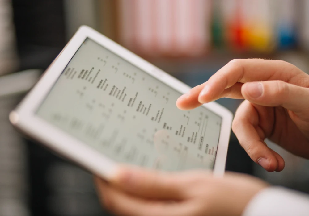 Clinician reviewing structured medical data on a digital tablet in a healthcare setting. 