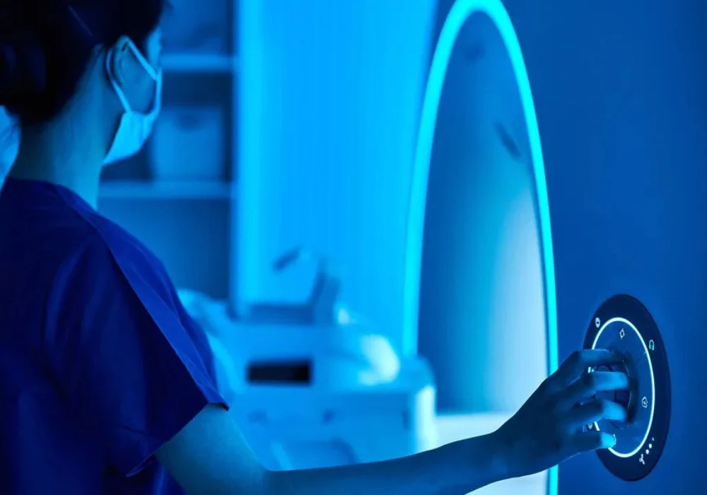 Radiology technician operating MRI machine in a hospital imaging room. 