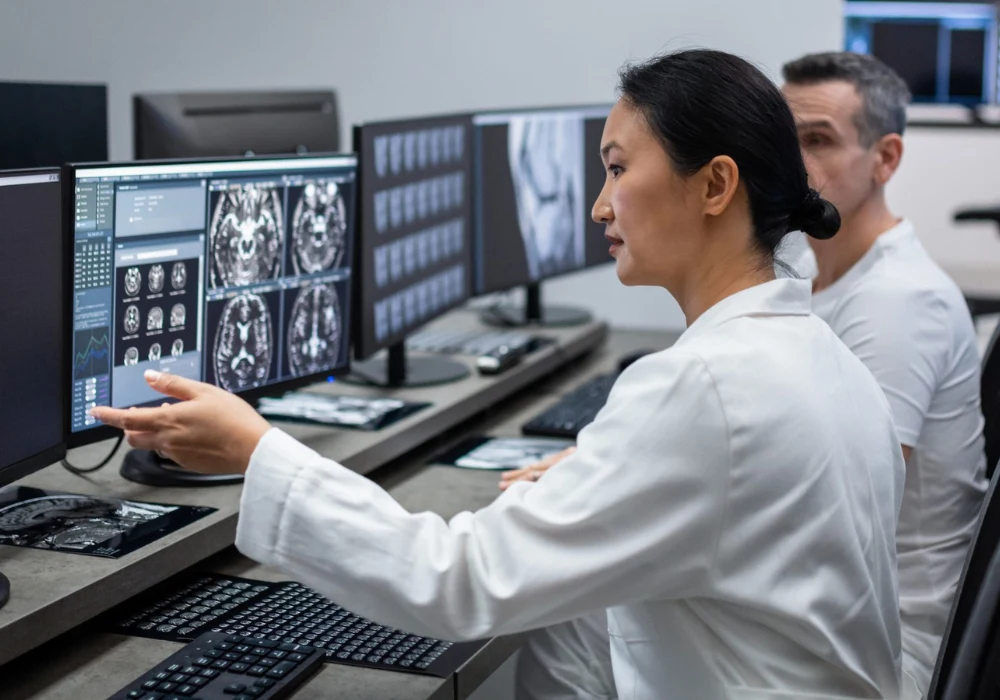 Radiologists analysing brain MRI scans on multiple monitors, representing advanced diagnostic imaging and collaborative medical review. 