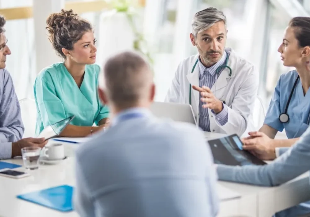 Medical and administrative professionals meeting in a hospital boardroom, representing collaborative healthcare leadership and strategic planning. 