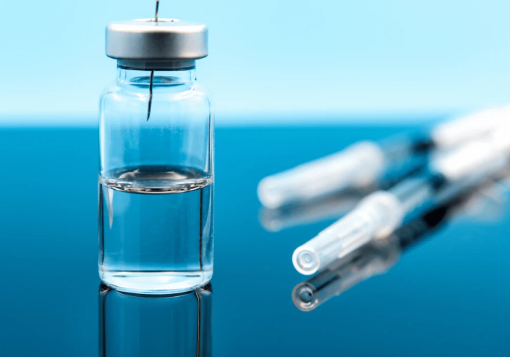 Close-up of a medical vial with a syringe needle, symbolising the precision handling of injectable therapies in clinical and laboratory settings.