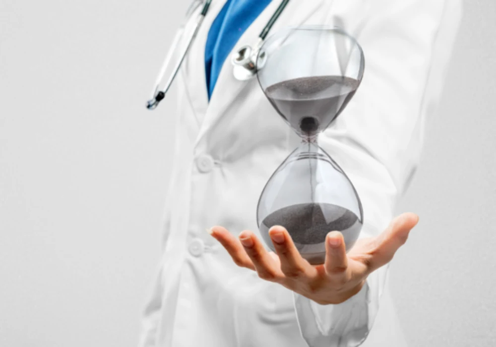 Doctor holding an hourglass symbolising time-critical decision making in medical care.