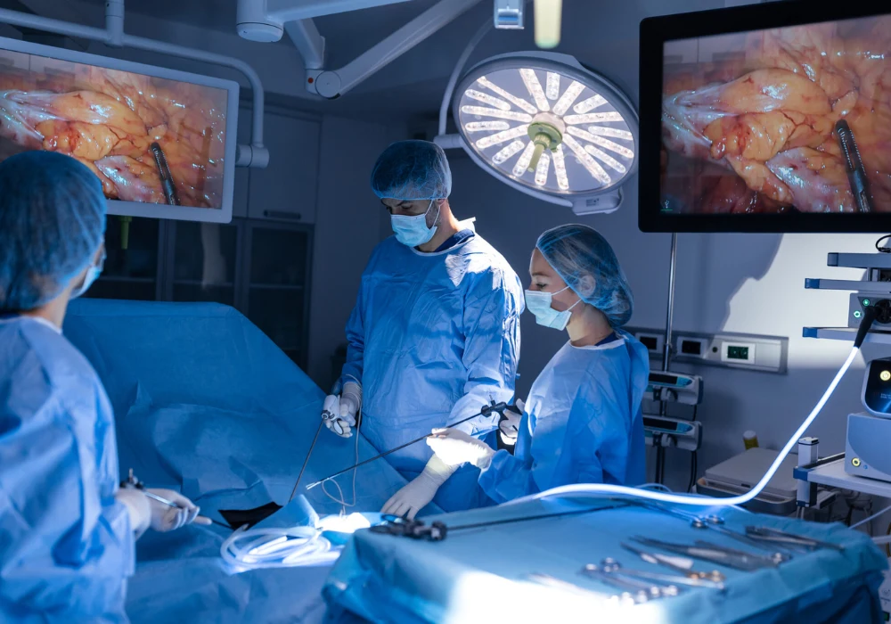 Surgical team performing a minimally invasive procedure using laparoscopic equipment, with real-time imaging displayed on monitors.