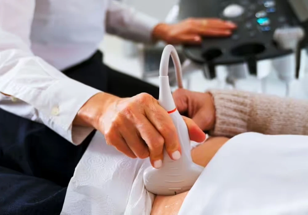 Clinician performing an abdominal ultrasound scan, supporting diagnostic imaging, patient assessment and point-of-care care.