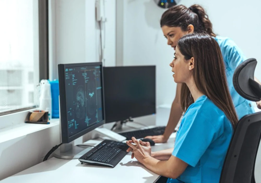 Healthcare staff reviewing brain imaging on a clinical workstation, supporting radiology workflow, diagnostic assessment and patient care coordination.