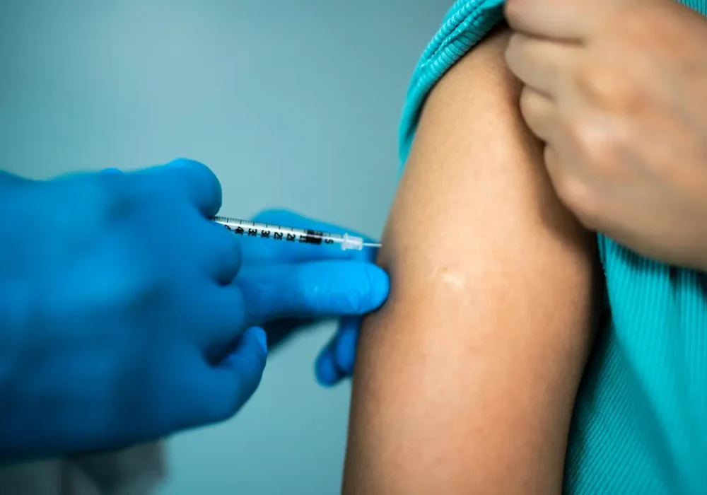 Patient receiving a vaccine injection, supporting immunisation, preventive healthcare, public health protection and clinical care.