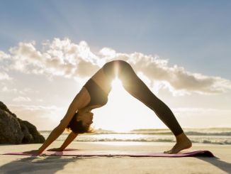 a-woman-practicing-yoga-on-the-beach