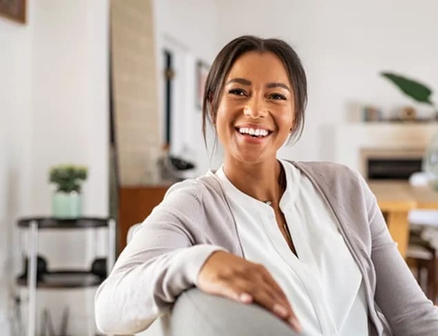 Healthy woman smiling towards the camera in her living room.