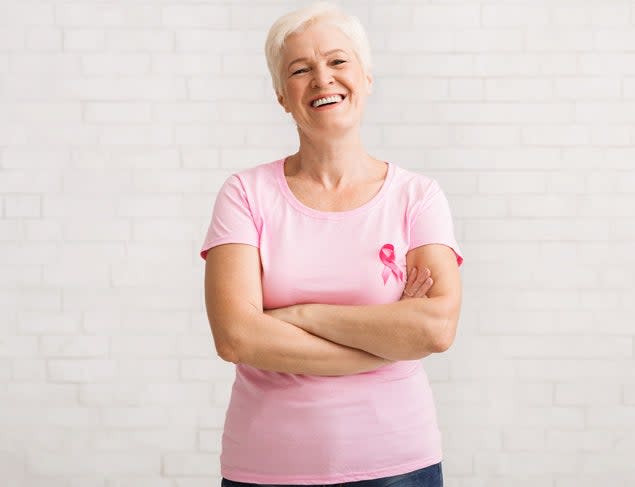 Happy woman, smiling,  in a pink t-shirt with a pink breast cancer awareness ribbon