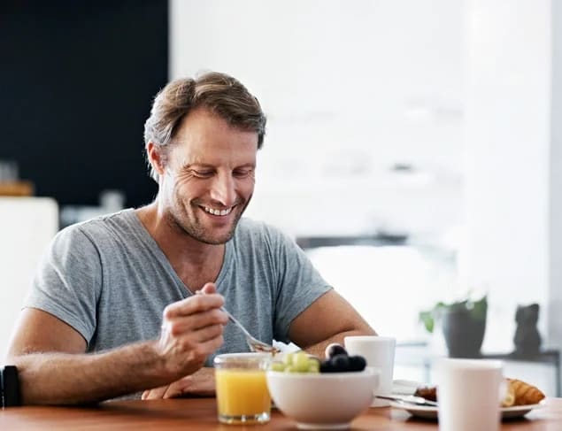 relaxed man at home eating a healthy breakfast of magnesium rich whole grain muesli