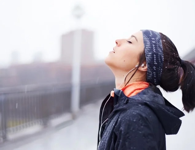 Young woman in navy blue and peach active wear exercising on a cold winter's day