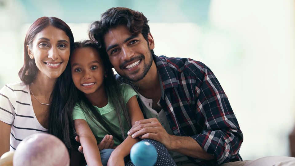 Photo of smiling family, a couple and their daughter