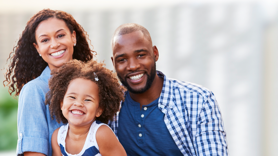 Photo of smiling family, a couple and their daughter