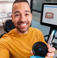 Photo of smiling man with clear aligner case