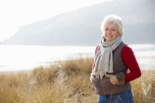 Well-off white woman in a field smiling with great teeth