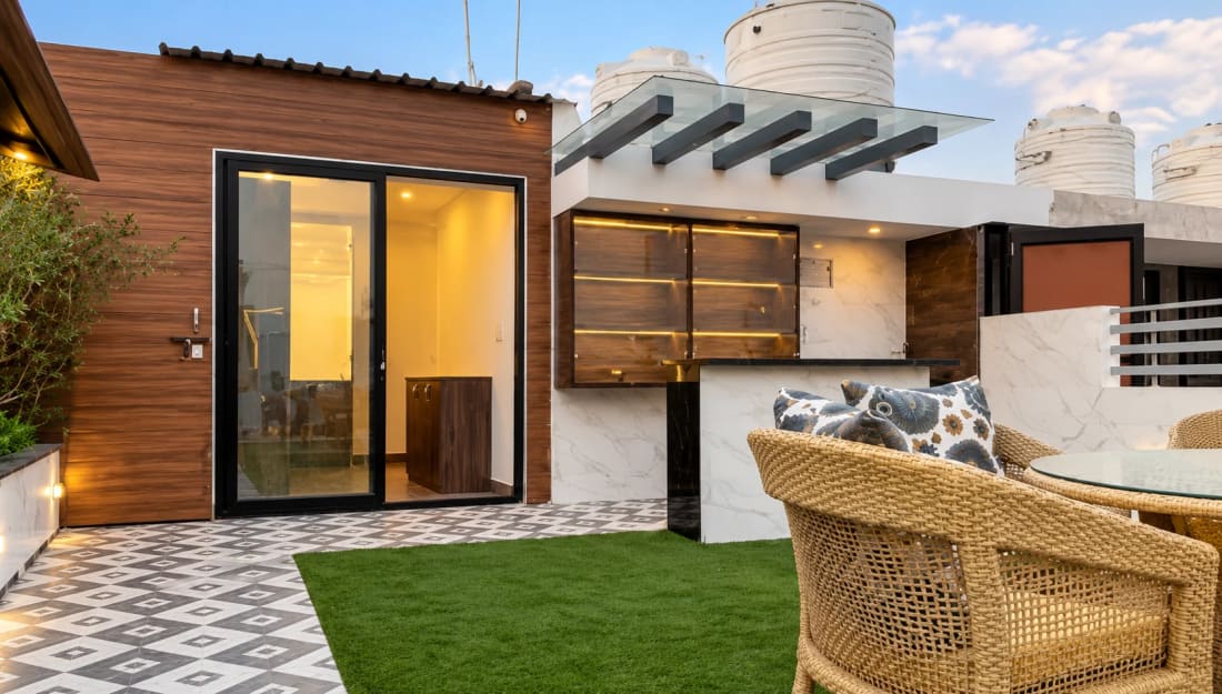 A rooftop pergola and outdoor seating beside a garden
