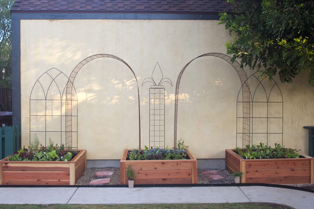 English Tudor Trio Border Garden | Straight on photo of three planted beds and trellising