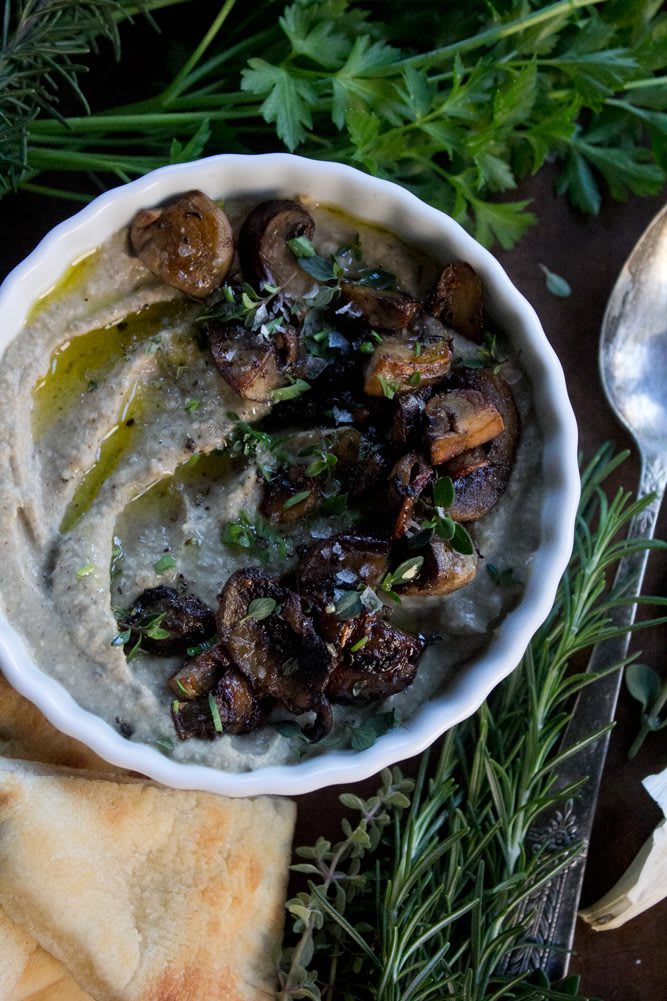 Mushroom Hummus with Thyme + Rosemary plated with parsley, sauteed mushrooms, rosemary and flatbread on the side