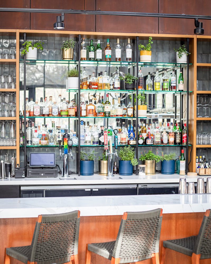 Library bar at Poppy & Seed in Anaheim, CA full of unique liquor and fresh garden herbs | Photo by Jill Cook