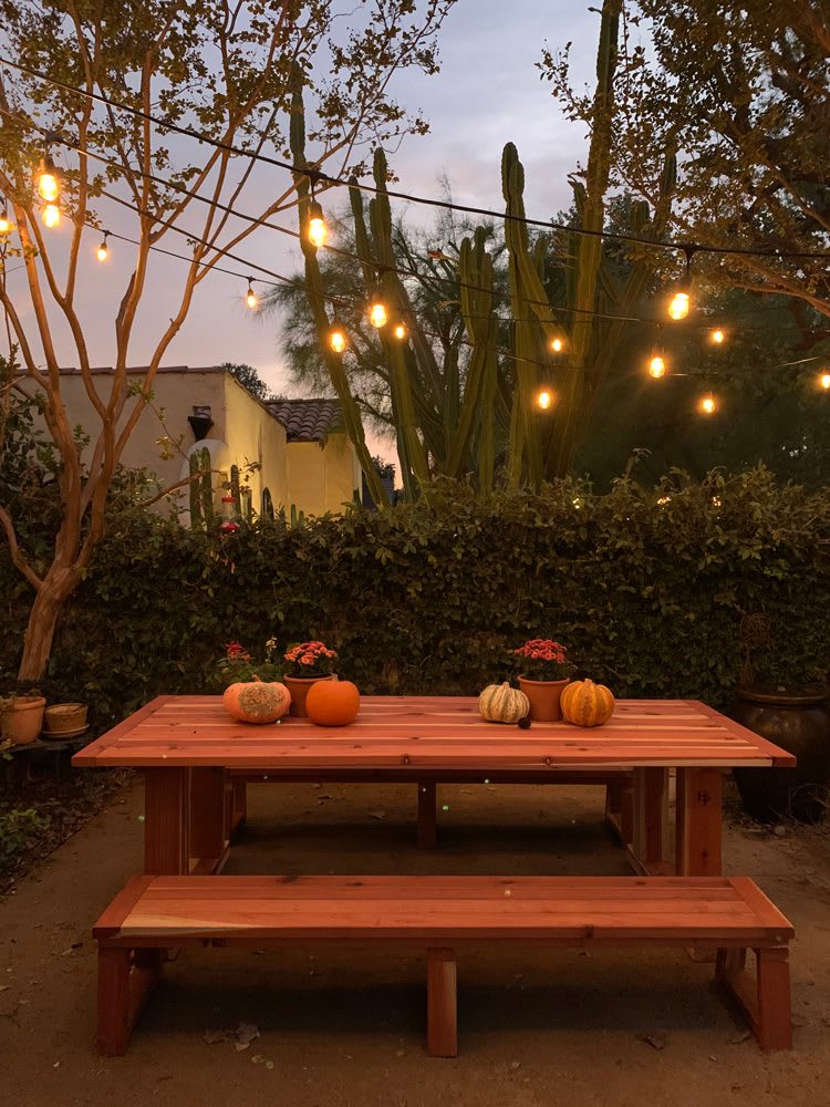 Heirloom Potager Showcase Garden Outdoor Dining Room at night with overhead outdoor string lights