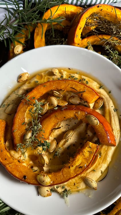 Honey Thyme Pumpkin Hummus | A nontraditional take on hummus for the cool season. Roasted pumpkin slices sit upon hummus drizzled with thyme, roasted pumpkin seeds, and local honey,