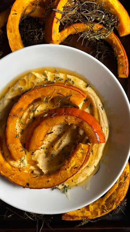 Honey Thyme Pumpking Hummus | Plated in a shallow bowl, finished with three slices of roasted pumpkin and fresh thyme, drizzled with local honey.