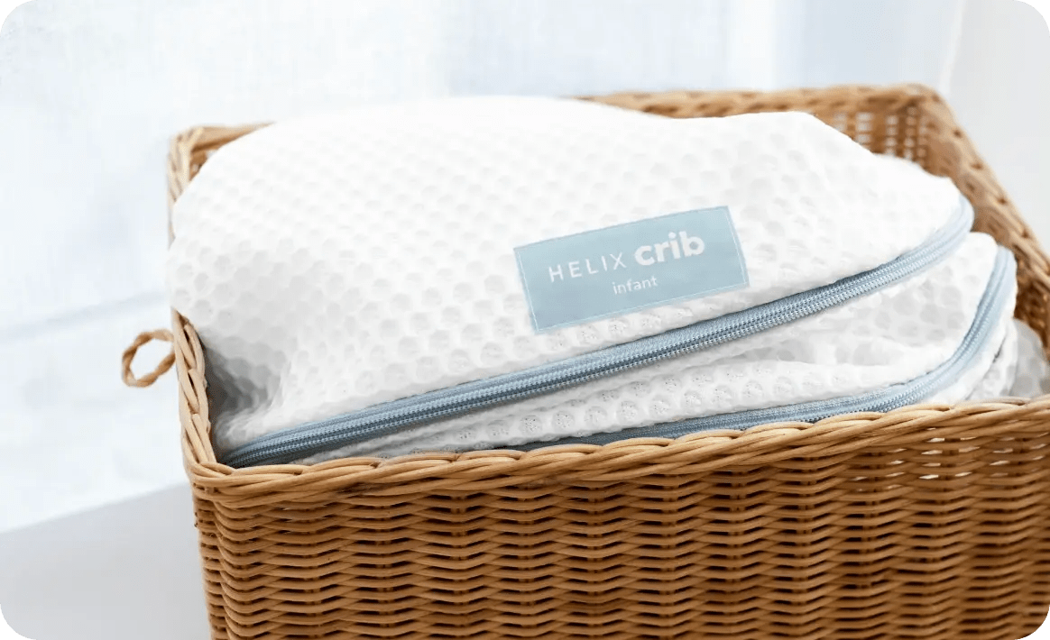An image of the Crib Mattress Cover in a basket