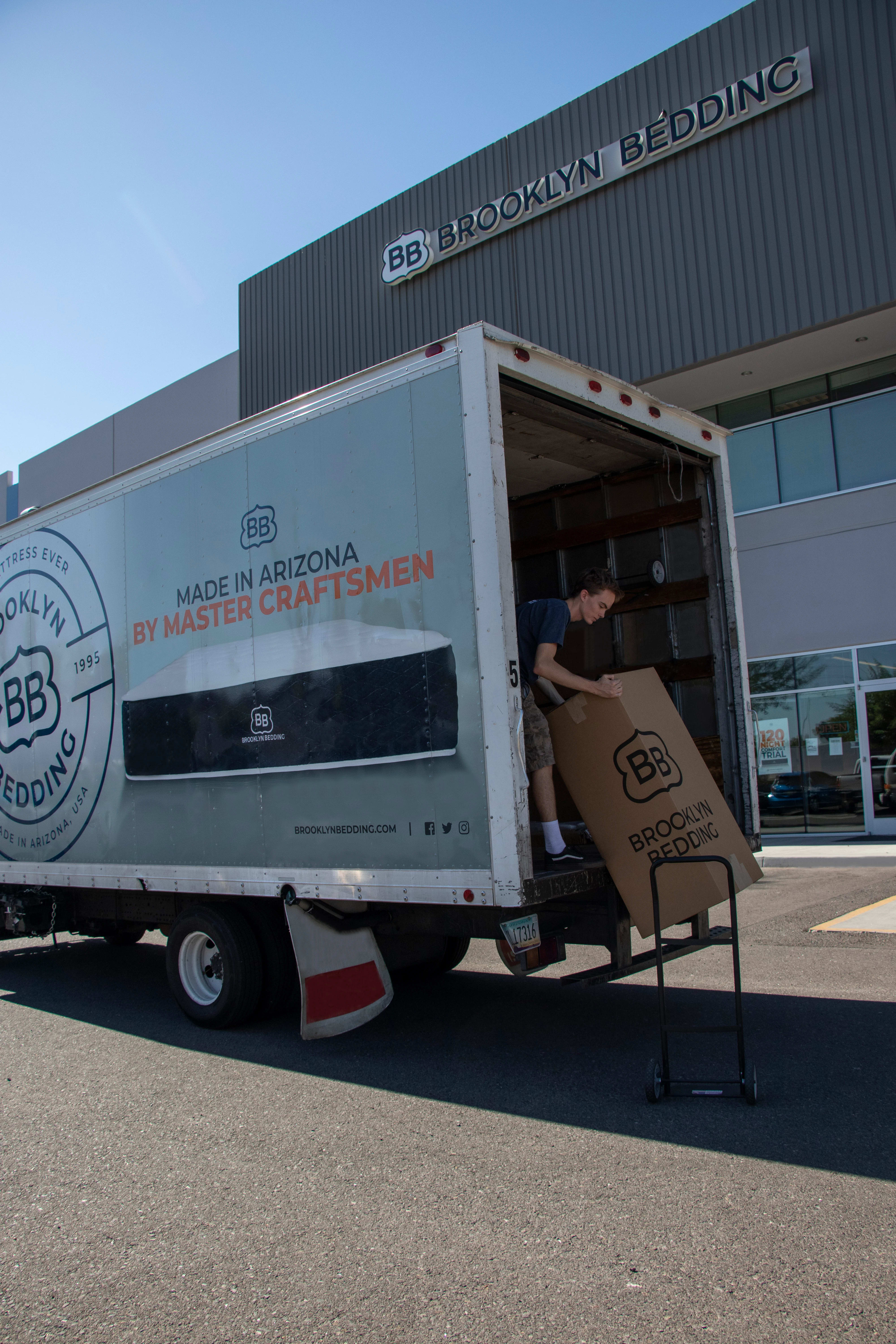 Person loading Brooklyn Bedding mattress box onto Delivery Truck outside of Brooklyn Bedding Factory